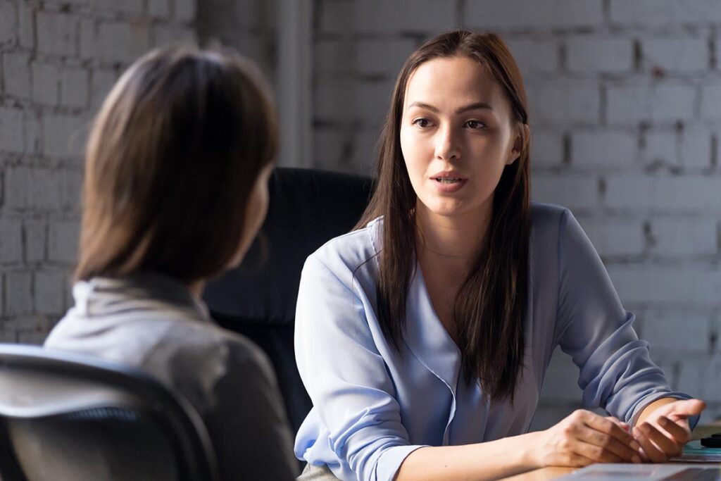 Two people discuss mental health treatment benefits